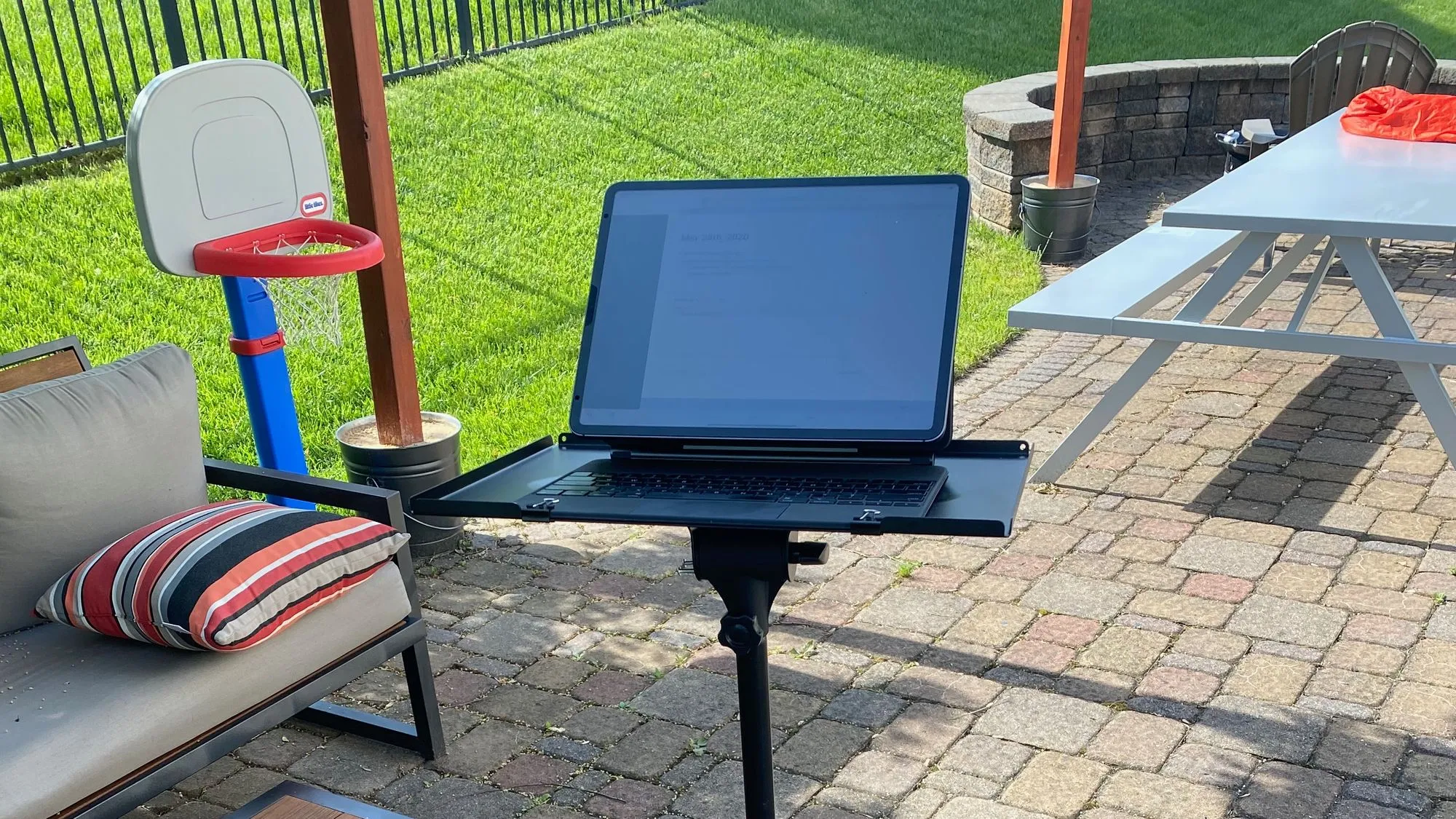 That's an iPad, on a Magic Keyboard, clipped to a music stand, whilst outside